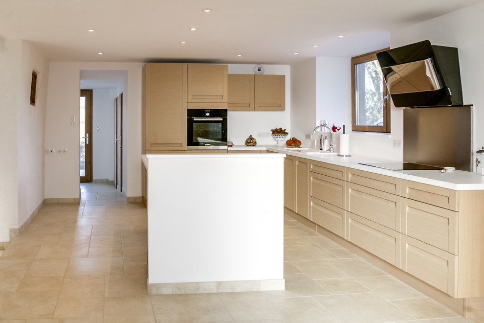 Idee per un cucina con isola centrale contemporaneo con ante in legno chiaro, paraspruzzi bianco e pavimento in pietra calcarea