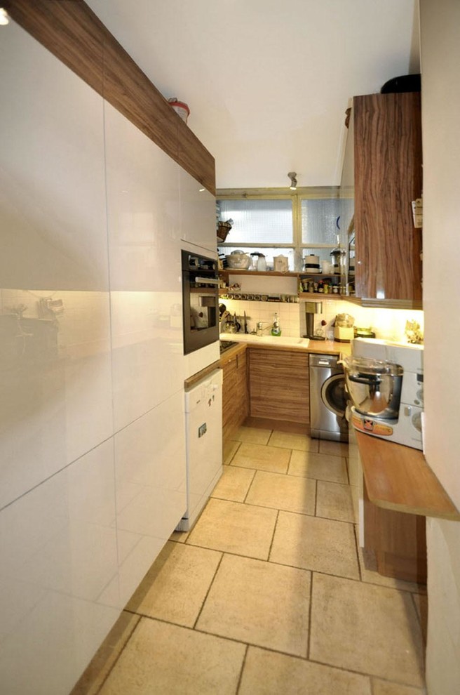 Immagine di una piccola cucina ad U minimal chiusa con ante lisce, ante bianche, top in legno e nessuna isola