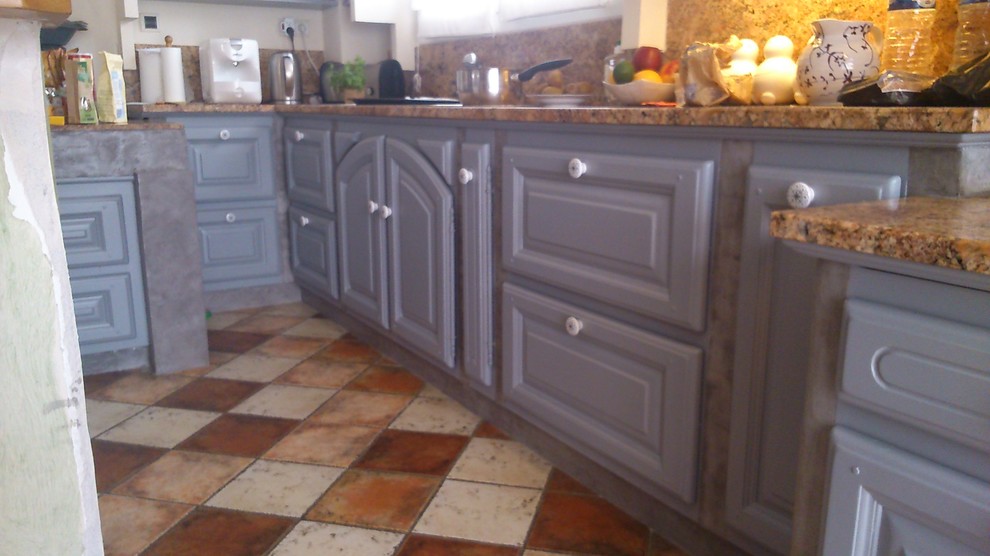 Immagine di una cucina ad U country con ante grigie, top in marmo, paraspruzzi a effetto metallico, paraspruzzi con piastrelle di metallo e pavimento in terracotta