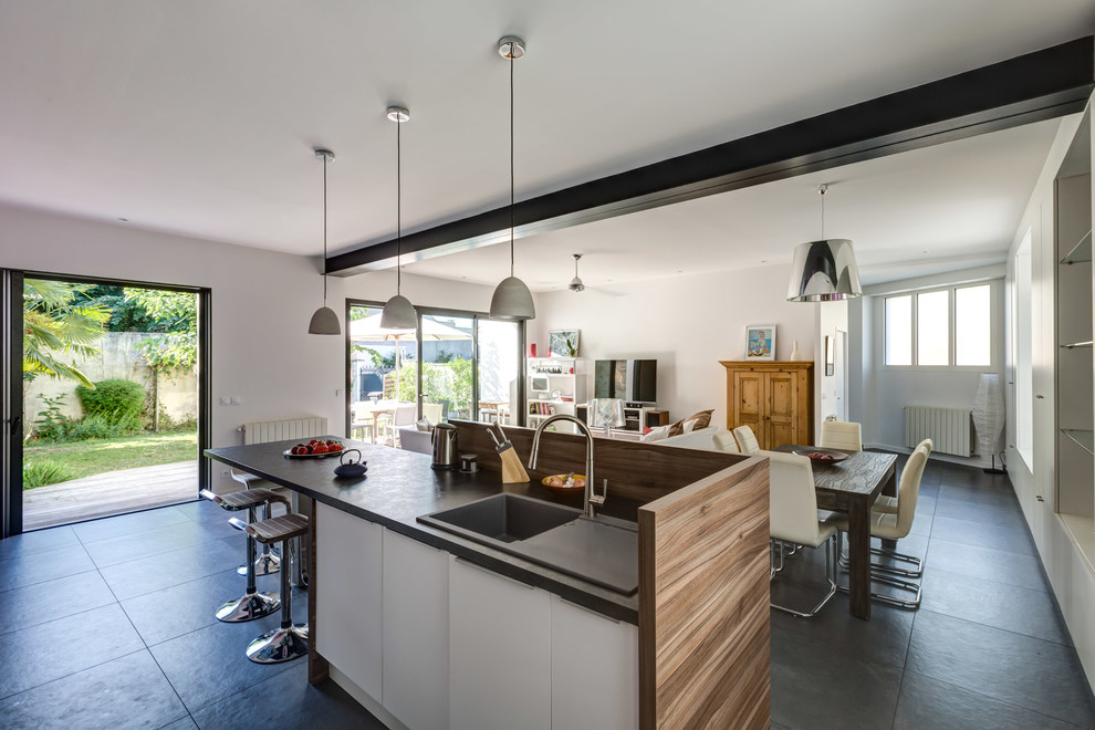 Стильный дизайн: параллельная кухня-гостиная среднего размера в современном стиле с белыми фасадами, полом из керамической плитки и островом - последний тренд