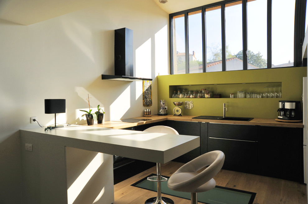 Источник вдохновения для домашнего уюта: п-образная кухня среднего размера в современном стиле с обеденным столом, черными фасадами и полуостровом