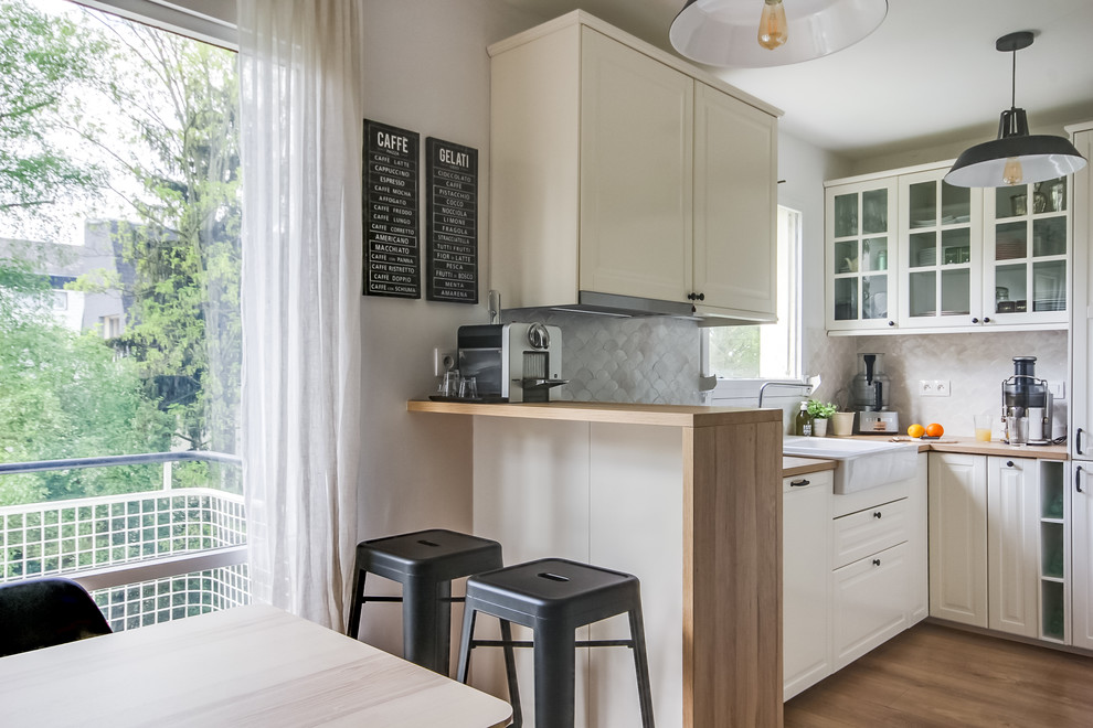 Moderne Küche mit Doppelwaschbecken, Glasfronten, weißen Schränken, Arbeitsplatte aus Holz, Küchenrückwand in Weiß, Elektrogeräten mit Frontblende und hellem Holzboden in Paris