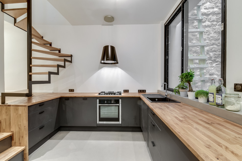 Foto di una grande cucina moderna con pavimento in cemento, nessuna isola e pavimento grigio