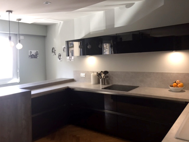 This is an example of a medium sized contemporary u-shaped kitchen/diner in Lyon with a submerged sink, flat-panel cabinets, grey cabinets, limestone worktops, limestone splashback, stainless steel appliances, light hardwood flooring and an island.