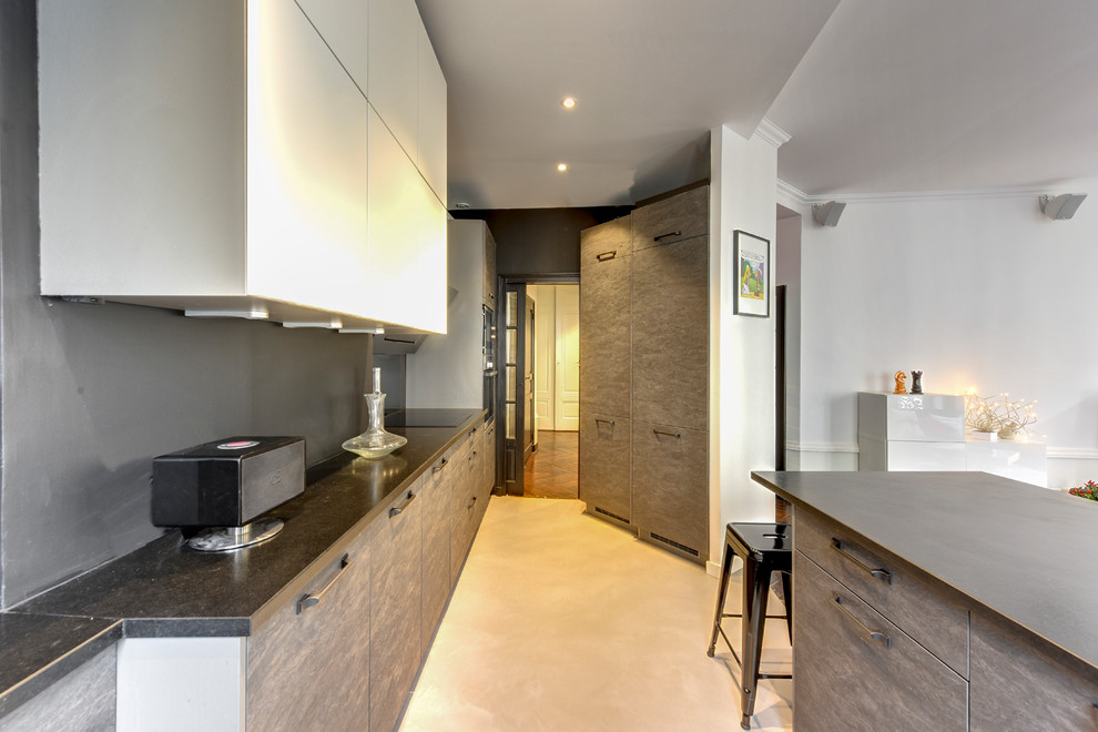 Imagen de cocina contemporánea de tamaño medio abierta con fregadero bajoencimera, salpicadero verde, electrodomésticos de acero inoxidable, suelo de cemento, una isla y suelo gris