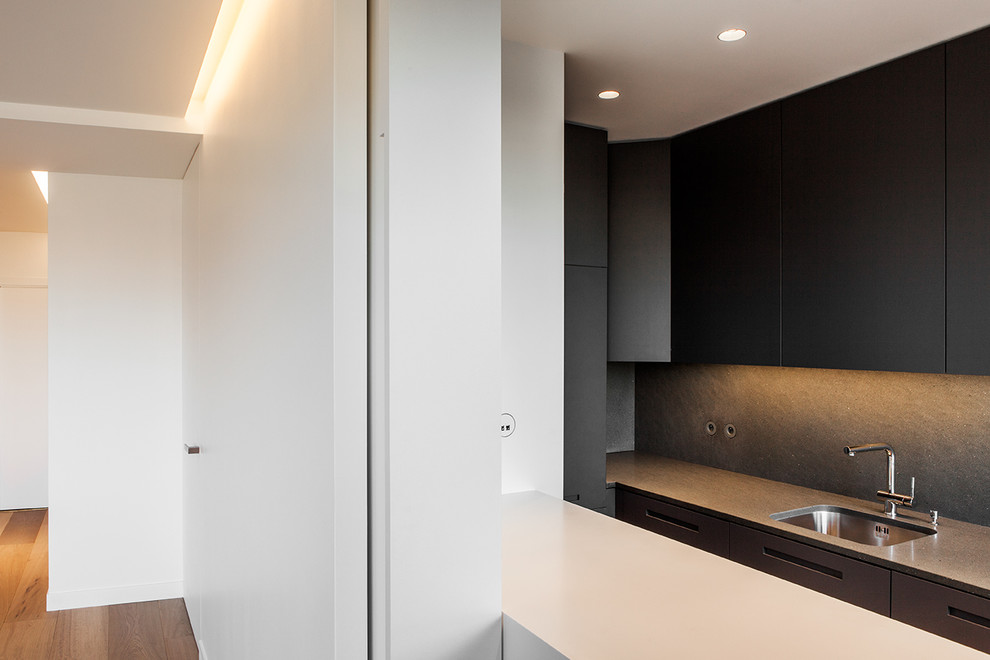 Idée de décoration pour une petite cuisine ouverte linéaire design avec une crédence noire et îlot.