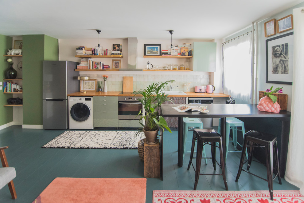 Exemple d'une cuisine ouverte linéaire éclectique de taille moyenne avec un plan de travail en bois, une crédence verte, une crédence en céramique, parquet peint et un sol bleu.