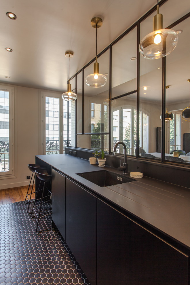 Mid-sized trendy single-wall porcelain tile and black floor open concept kitchen photo in Paris with an undermount sink, black cabinets, an island and black countertops