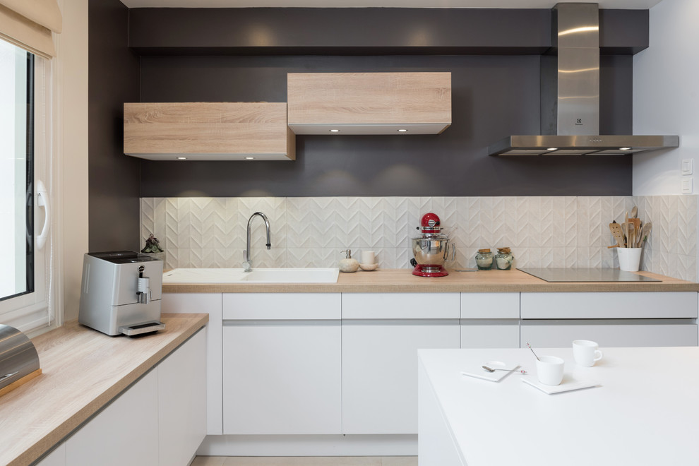 Idéer för mellanstora funkis linjära kök med öppen planlösning, med luckor med profilerade fronter, vita skåp, marmorbänkskiva, vitt stänkskydd, rostfria vitvaror, ljust trägolv, en köksö och beiget golv
