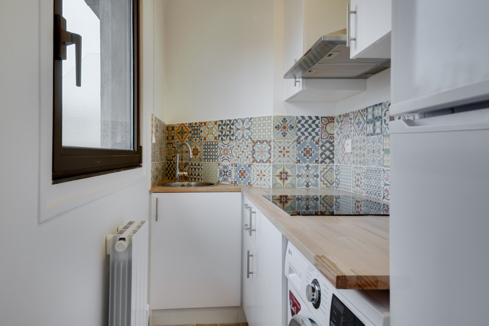 Kleine Moderne Küche in L-Form mit integriertem Waschbecken, Arbeitsplatte aus Holz, Rückwand aus Zementfliesen und weißen Elektrogeräten in Paris