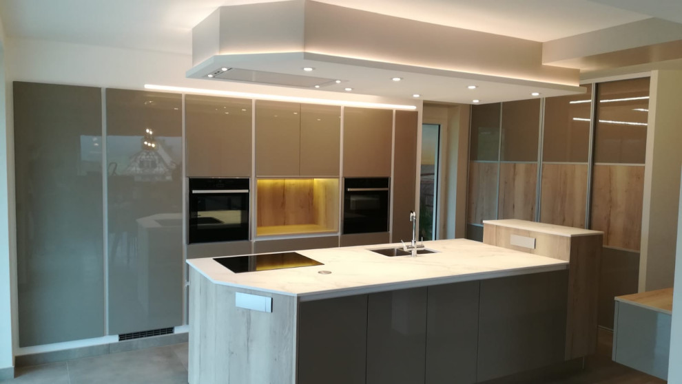 Design ideas for a medium sized contemporary galley kitchen/diner in Strasbourg with a submerged sink, integrated appliances, an island and white worktops.