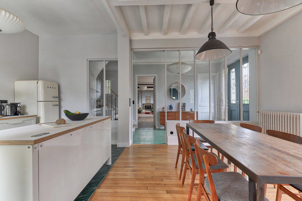 Immagine di una cucina minimal di medie dimensioni con lavello sottopiano, ante a filo, ante bianche, parquet chiaro, pavimento beige, top bianco e travi a vista
