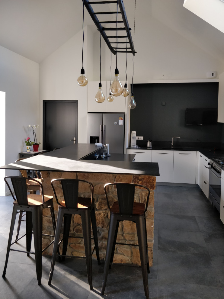 Photo of a large urban l-shaped open plan kitchen in Rennes with a submerged sink, beaded cabinets, stainless steel appliances, ceramic flooring, an island, grey floors and black worktops.