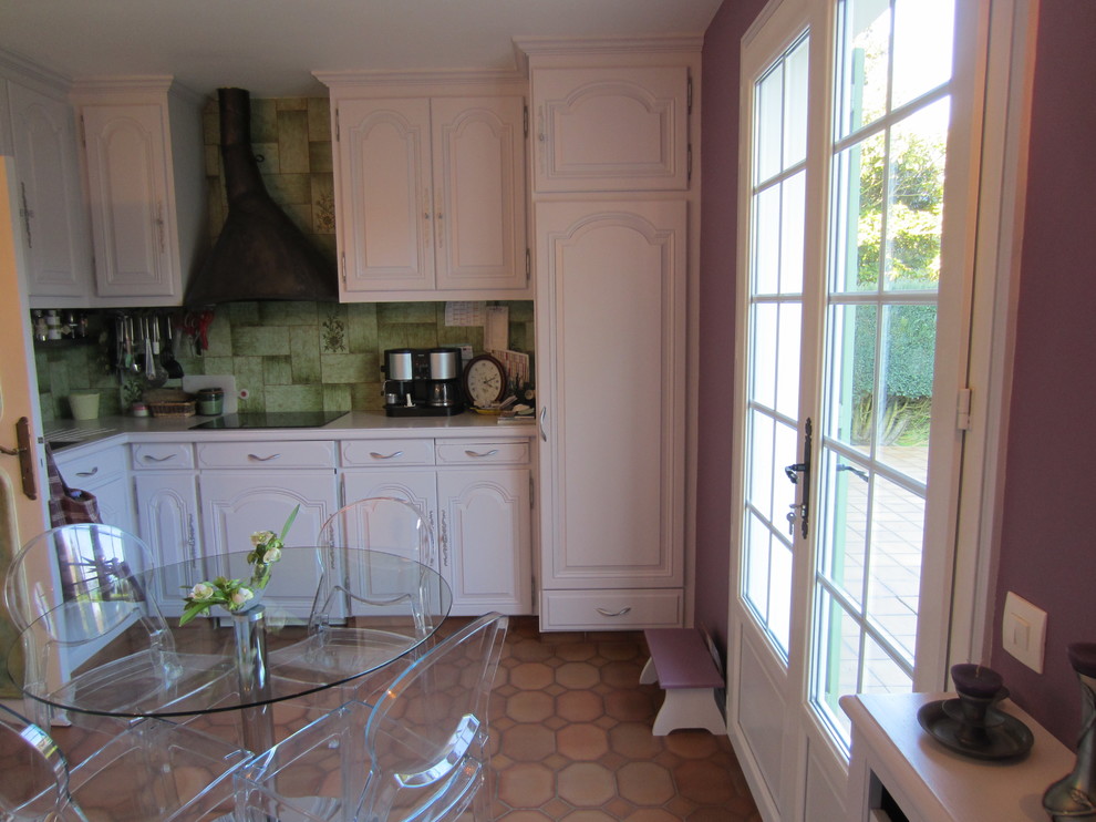 パリにある中くらいなトラディショナルスタイルのおしゃれなキッチン (シングルシンク、シェーカースタイル扉のキャビネット、白いキャビネット、御影石カウンター、緑のキッチンパネル、セラミックタイルのキッチンパネル、シルバーの調理設備、テラコッタタイルの床、赤い床) の写真