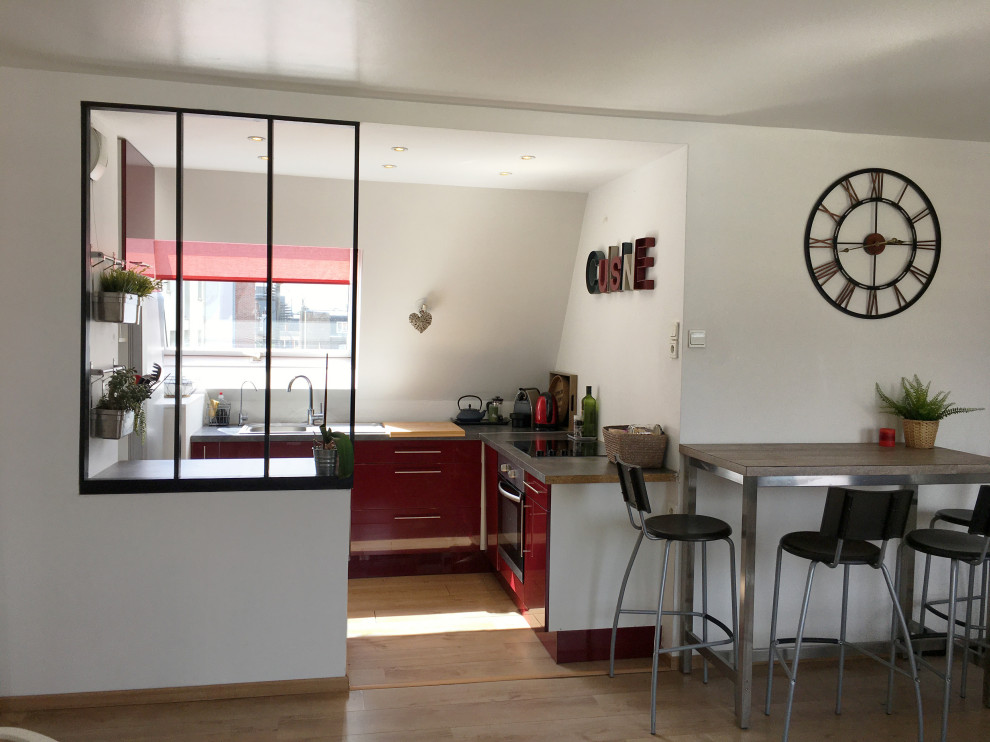 Bild på ett mellanstort funkis grå grått kök, med en undermonterad diskho, luckor med profilerade fronter, röda skåp, träbänkskiva, integrerade vitvaror, ljust trägolv och beiget golv