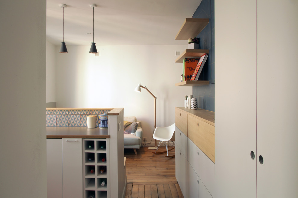 Cette photo montre une petite cuisine ouverte encastrable scandinave en U avec un placard à porte plane, des portes de placard grises, une crédence bleue, une crédence en céramique, parquet clair et aucun îlot.