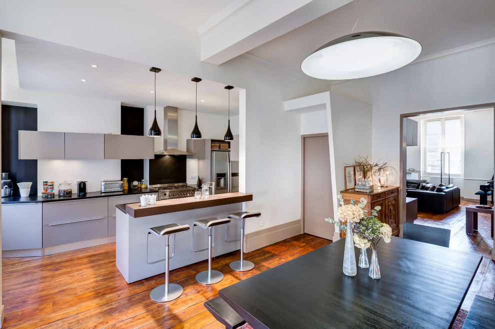 Zweizeilige, Mittelgroße Moderne Wohnküche mit grauen Schränken und Kücheninsel in Bordeaux