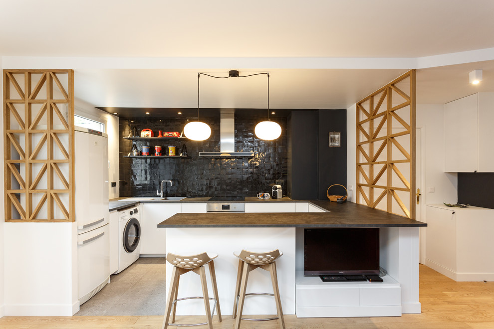 Exempel på ett mellanstort minimalistiskt svart svart kök, med släta luckor, vita skåp, laminatbänkskiva, svart stänkskydd, stänkskydd i terrakottakakel, klinkergolv i porslin, grått golv, en nedsänkt diskho, vita vitvaror och en halv köksö