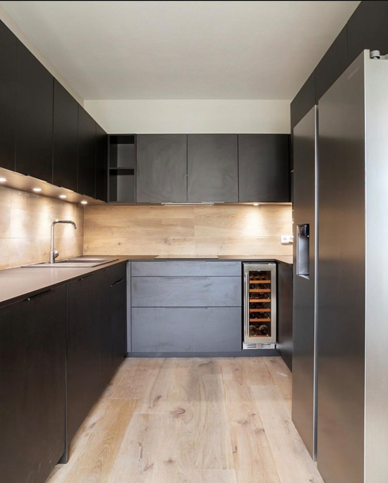 Idéer för ett stort modernt svart kök med öppen planlösning, med en undermonterad diskho, svarta skåp, träbänkskiva och ljust trägolv