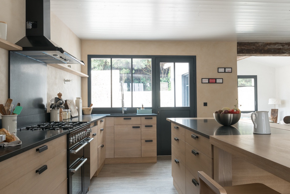 Ejemplo de cocina costera grande con puertas de armario de madera clara, encimera de granito y una isla