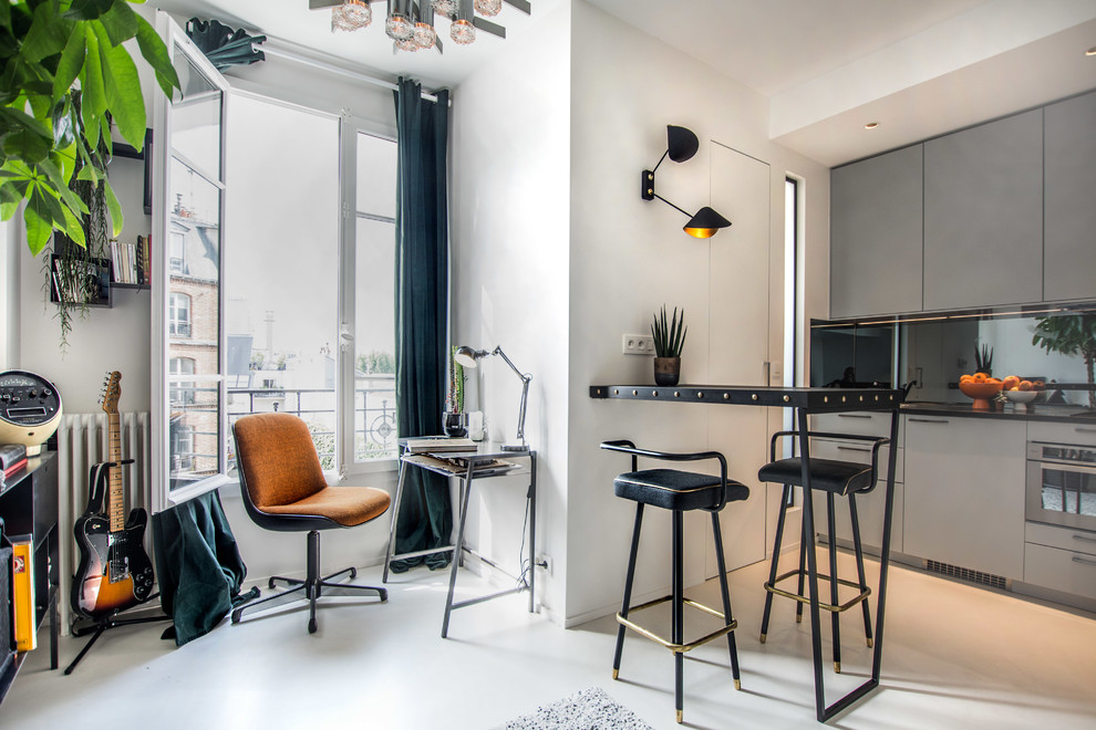 Offene, Kleine Moderne Küche mit flächenbündigen Schrankfronten, grauen Schränken, Küchenrückwand in Schwarz, Glasrückwand, Halbinsel und weißem Boden in Paris