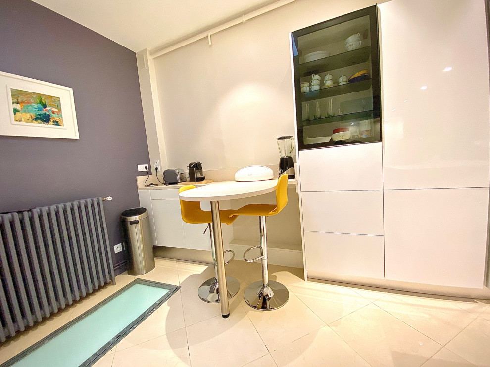 Photo of a large contemporary l-shaped enclosed kitchen in Other with a submerged sink, beaded cabinets, white cabinets, limestone worktops, beige splashback, limestone splashback, black appliances, marble flooring, no island, beige floors and beige worktops.