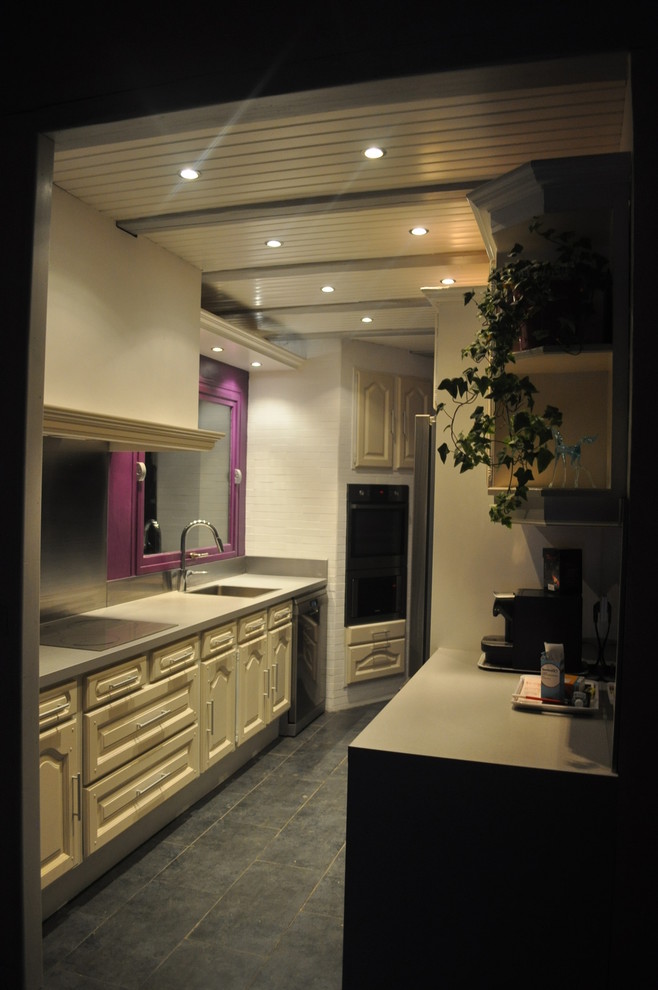 Aménagement d'une cuisine ouverte parallèle campagne de taille moyenne avec des portes de placard blanches, un plan de travail en stratifié, une crédence métallisée, un électroménager en acier inoxydable et aucun îlot.