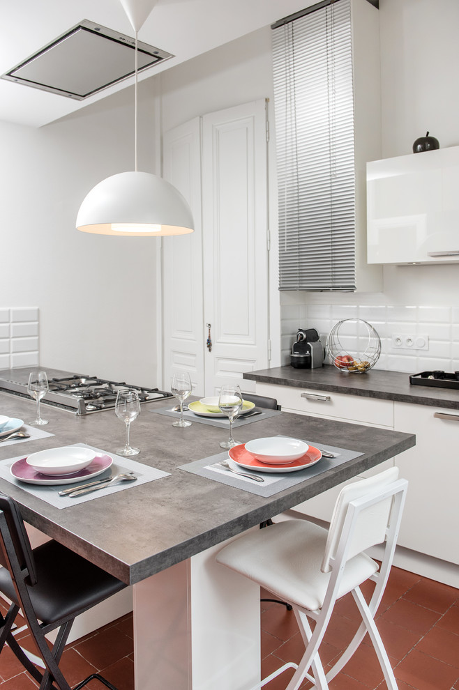 Imagen de cocina comedor contemporánea de tamaño medio con armarios con paneles lisos, puertas de armario blancas, salpicadero blanco, salpicadero de azulejos tipo metro y una isla