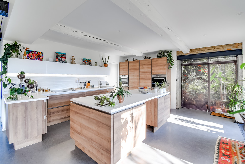 Foto på ett stort eklektiskt vit u-kök, med släta luckor, skåp i mellenmörkt trä, vitt stänkskydd, betonggolv, en köksö, grått golv, en undermonterad diskho, laminatbänkskiva och rostfria vitvaror