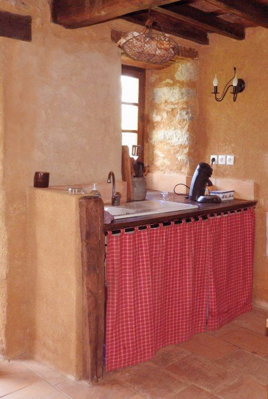 На фото: параллельная кухня-гостиная среднего размера в стиле кантри с накладной мойкой, деревянной столешницей, черной техникой, полом из терракотовой плитки, открытыми фасадами и красным фартуком
