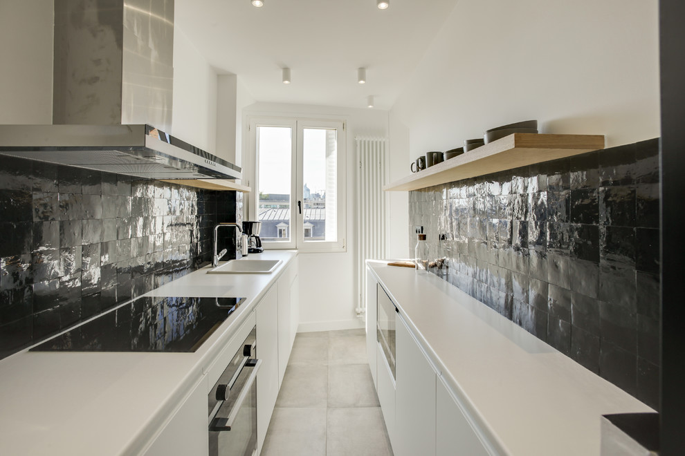 Foto di una cucina parallela nordica con lavello da incasso, ante lisce, ante bianche, paraspruzzi nero, elettrodomestici neri, nessuna isola, pavimento bianco e top bianco