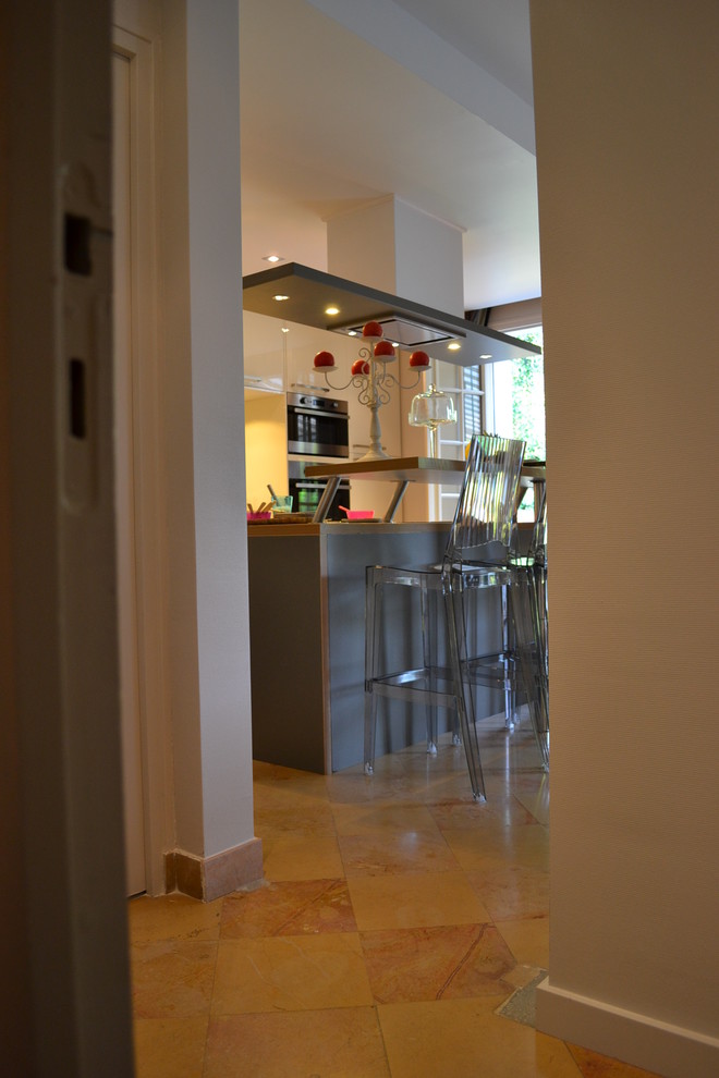 Idéer för ett mellanstort modernt kök, med en undermonterad diskho, släta luckor, vita skåp, laminatbänkskiva, spegel som stänkskydd, rostfria vitvaror, klinkergolv i keramik, en köksö och orange golv