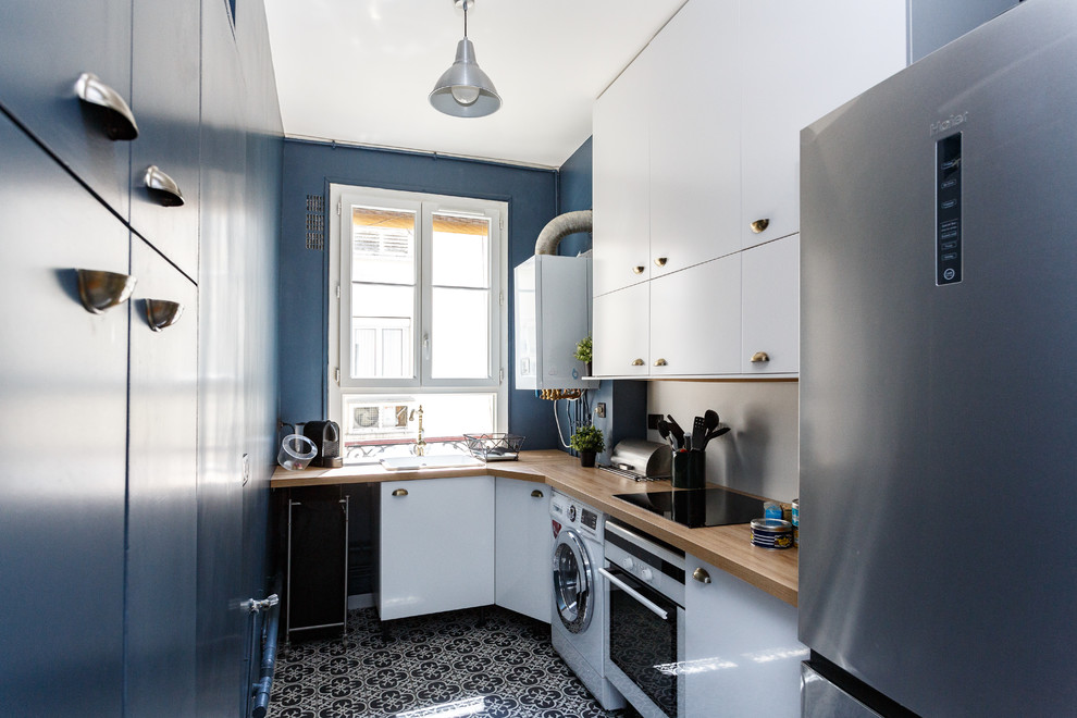 Immagine di una cucina parallela design chiusa con lavello da incasso, ante lisce, ante blu, top in legno, paraspruzzi beige, elettrodomestici in acciaio inossidabile, nessuna isola, pavimento multicolore e top beige