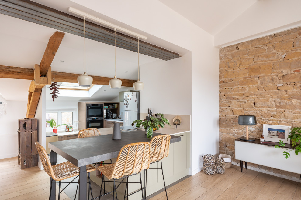Immagine di una cucina scandinava con ante lisce, ante beige, elettrodomestici in acciaio inossidabile, parquet chiaro, pavimento beige, top grigio, travi a vista e soffitto a volta