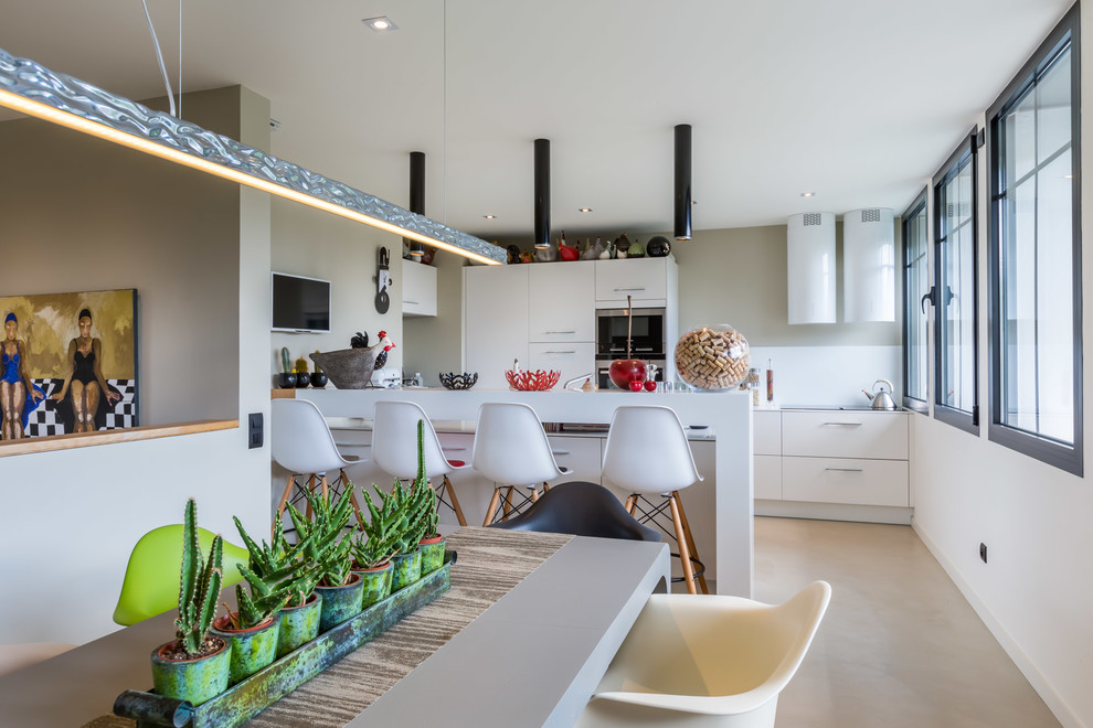 This is an example of a contemporary galley kitchen/diner in Bordeaux with flat-panel cabinets, white cabinets, white splashback, stainless steel appliances, an island and beige floors.