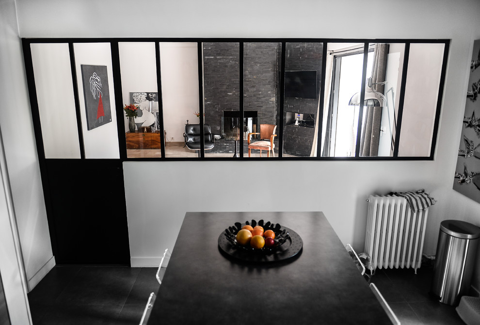 Idee per un cucina con isola centrale minimalista di medie dimensioni e chiuso con ante a filo, paraspruzzi nero, elettrodomestici in acciaio inossidabile, pavimento con piastrelle in ceramica, pavimento nero e top nero