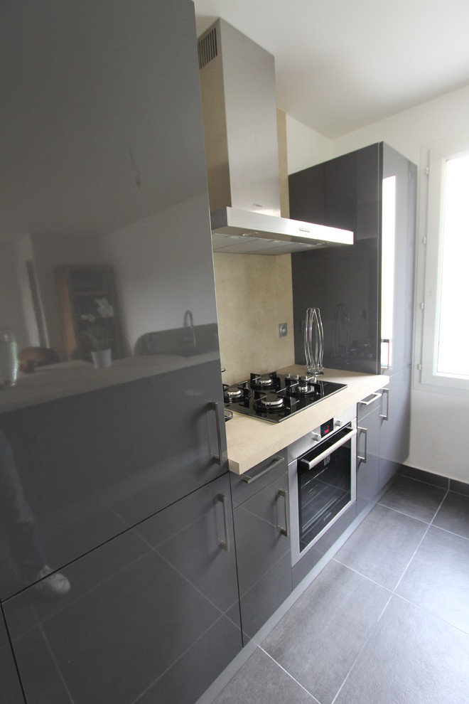 Idee per una cucina chic di medie dimensioni con ante nere, top in laminato, paraspruzzi grigio, pavimento in legno massello medio e pavimento nero