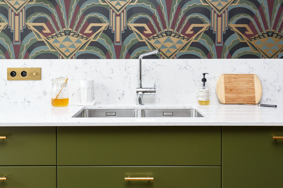 Bild på ett mellanstort funkis vit linjärt vitt kök och matrum, med en undermonterad diskho, släta luckor, gröna skåp, marmorbänkskiva, vitt stänkskydd, stänkskydd i marmor, integrerade vitvaror, mellanmörkt trägolv, en köksö och brunt golv