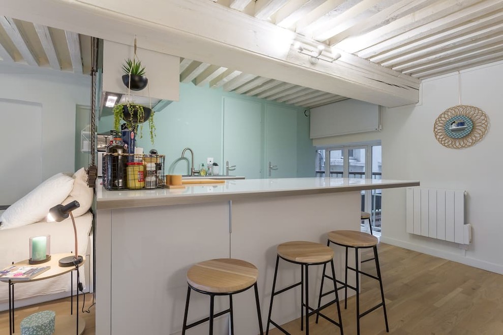 Immagine di una cucina scandinava di medie dimensioni con lavello integrato, parquet chiaro, penisola, pavimento beige e top grigio