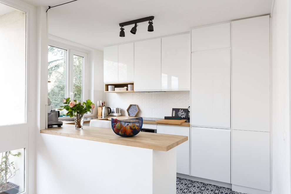 Exempel på ett litet modernt beige beige kök, med släta luckor, vita skåp, träbänkskiva, vitt stänkskydd, stänkskydd i keramik, rostfria vitvaror, cementgolv, blått golv, en undermonterad diskho och en halv köksö