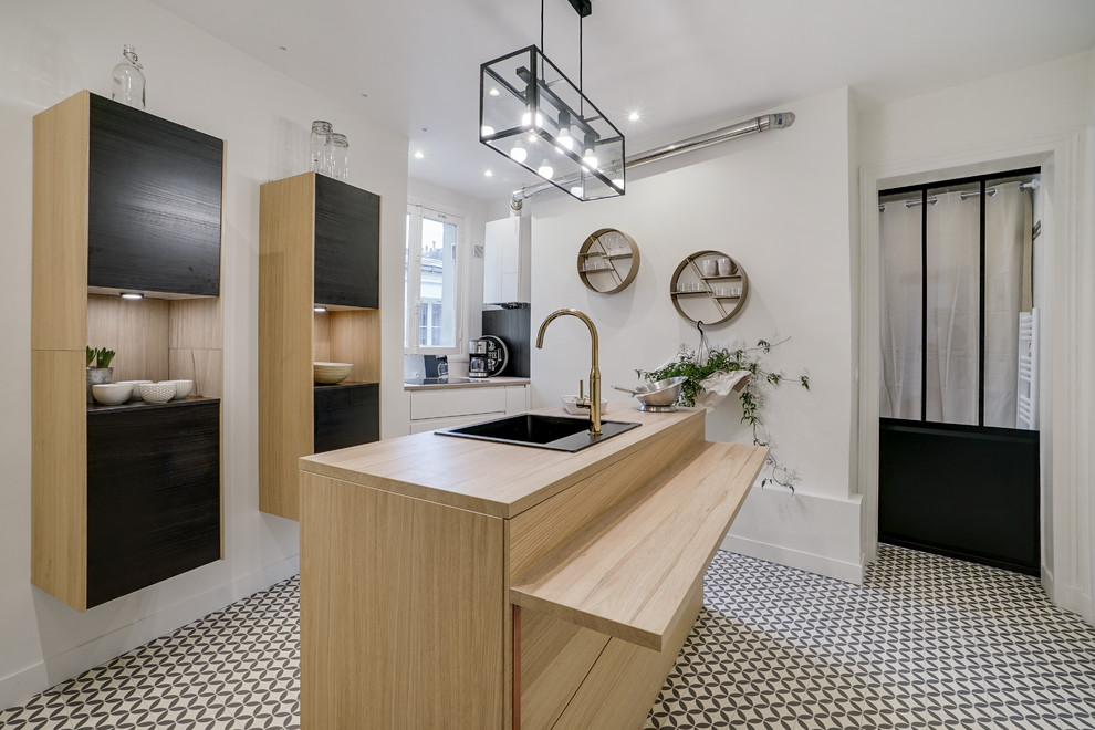 Zweizeilige Klassische Küche mit Einbauwaschbecken, flächenbündigen Schrankfronten, hellen Holzschränken, Arbeitsplatte aus Holz, buntem Boden und beiger Arbeitsplatte in Paris