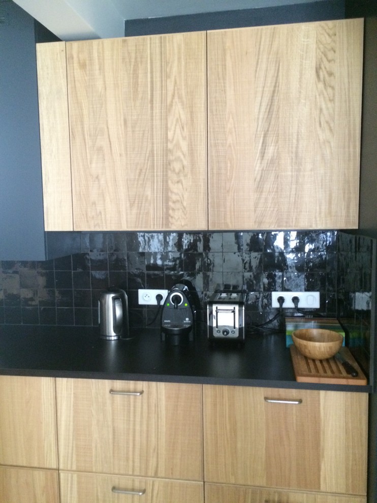 Foto di una cucina scandinava con lavello sottopiano, ante in legno chiaro, top in laminato, paraspruzzi nero, paraspruzzi con piastrelle in terracotta, elettrodomestici da incasso e pavimento in cemento