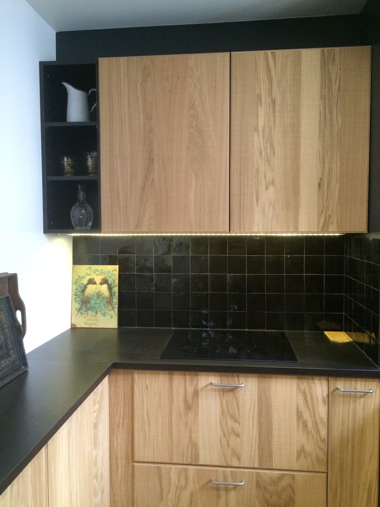 Immagine di una cucina nordica con lavello sottopiano, ante in legno chiaro, top in laminato, paraspruzzi nero, paraspruzzi con piastrelle in terracotta, elettrodomestici da incasso e pavimento in cemento