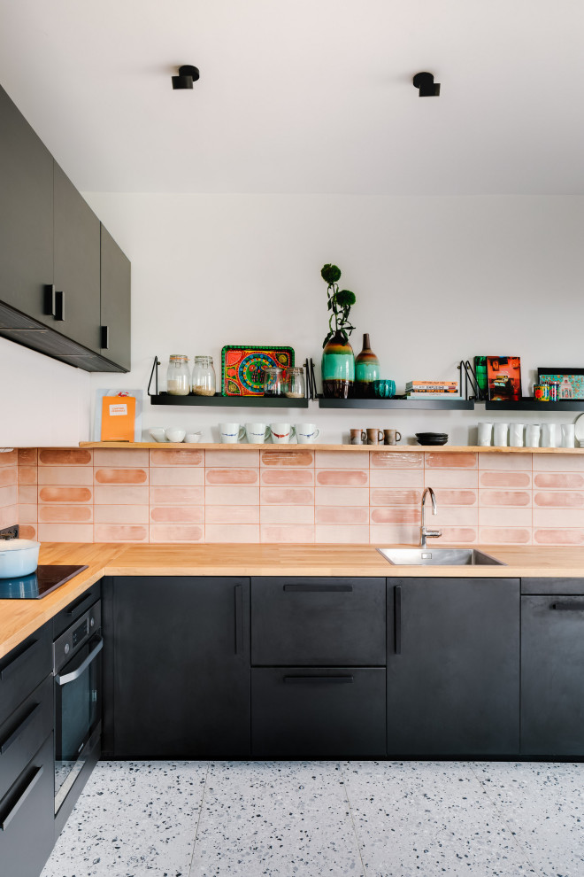 Inspiration for a contemporary l-shaped gray floor eat-in kitchen remodel in Paris with a drop-in sink, flat-panel cabinets, black cabinets, wood countertops, pink backsplash and brown countertops