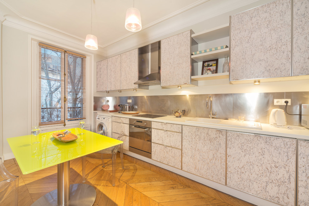 Einzeilige, Mittelgroße Moderne Wohnküche ohne Insel mit Waschbecken, weißen Schränken, Küchenrückwand in Metallic, Küchengeräten aus Edelstahl und braunem Holzboden in Paris