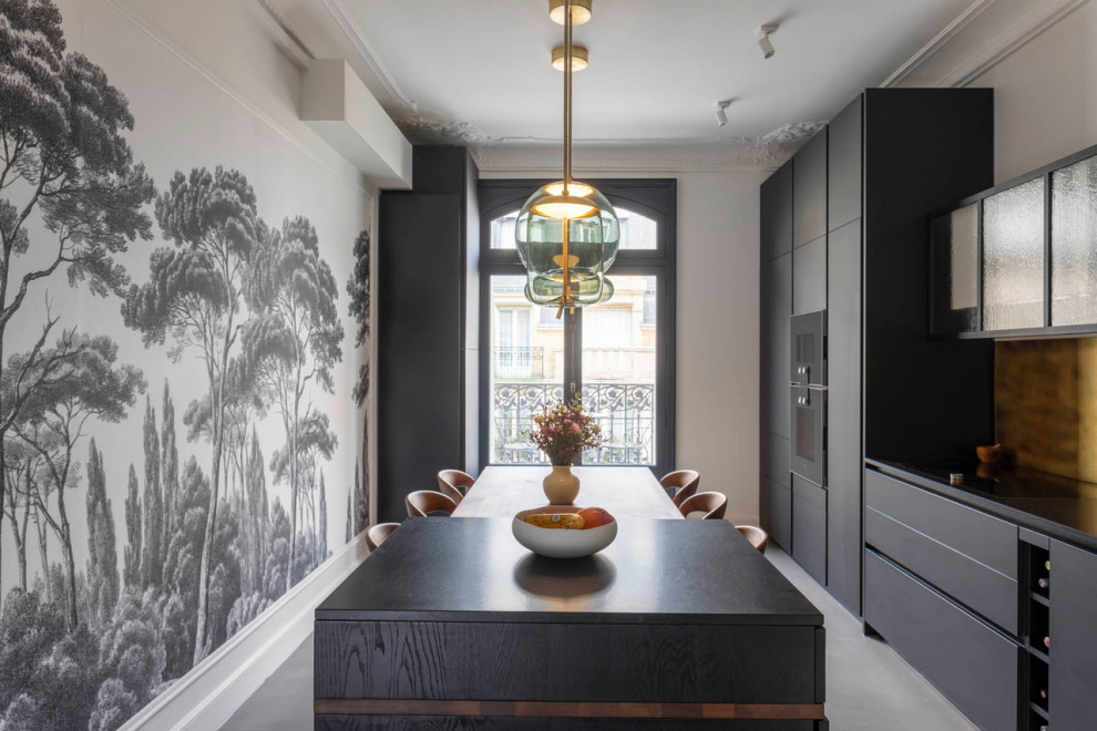 Exempel på ett avskilt, stort modernt svart linjärt svart kök, med en undermonterad diskho, svarta skåp, granitbänkskiva, stänkskydd med metallisk yta, integrerade vitvaror, betonggolv, en köksö och grått golv