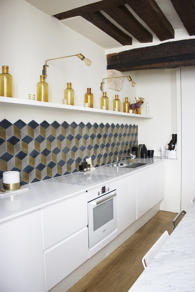 Exempel på ett mellanstort modernt linjärt kök med öppen planlösning, med en undermonterad diskho, bänkskiva i kvartsit, flerfärgad stänkskydd, stänkskydd i cementkakel, vita vitvaror, ljust trägolv, släta luckor, vita skåp och brunt golv