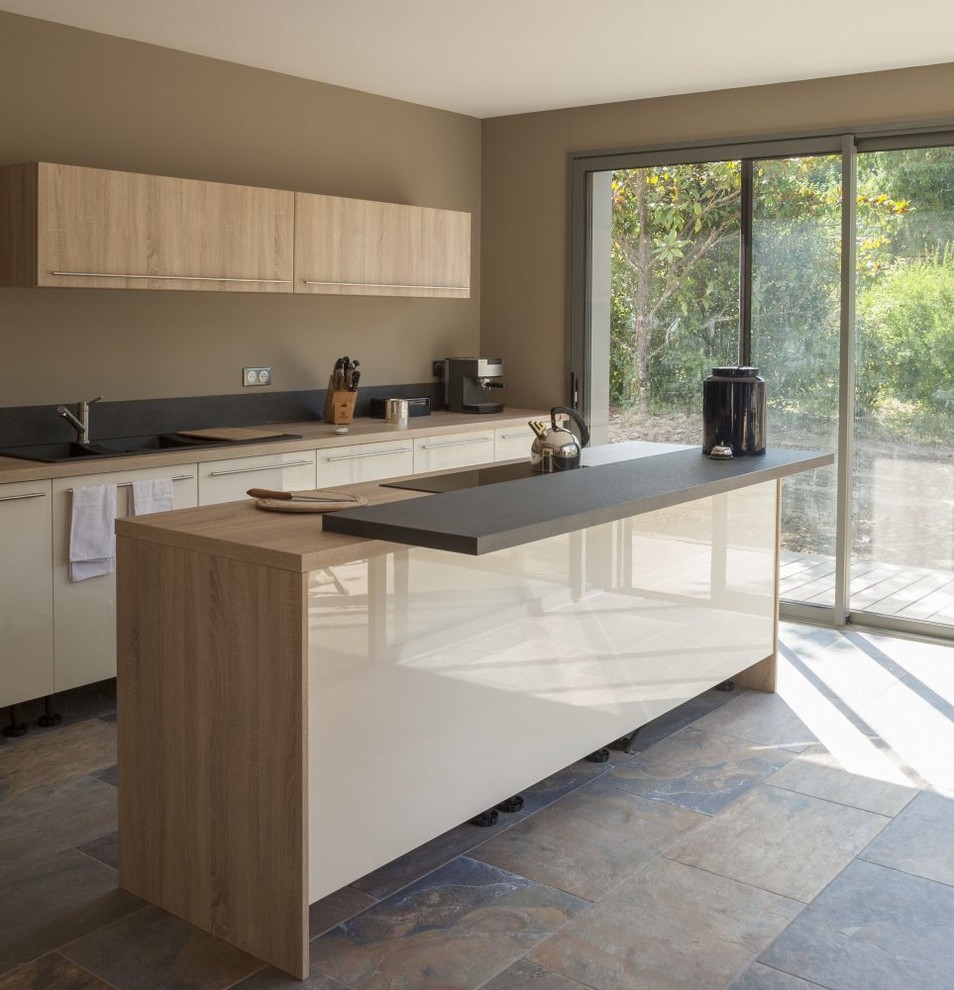 Inspiration för minimalistiska kök, med släta luckor, vita skåp, träbänkskiva, en köksö och flerfärgat golv