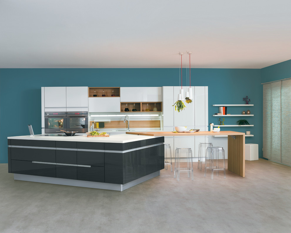 Imagen de cocina actual grande abierta con puertas de armario blancas, salpicadero blanco, electrodomésticos de acero inoxidable y una isla