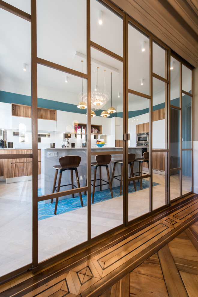Große Klassische Wohnküche in L-Form mit Küchenrückwand in Weiß, Küchengeräten aus Edelstahl, Porzellan-Bodenfliesen, Kücheninsel und blauem Boden in Paris